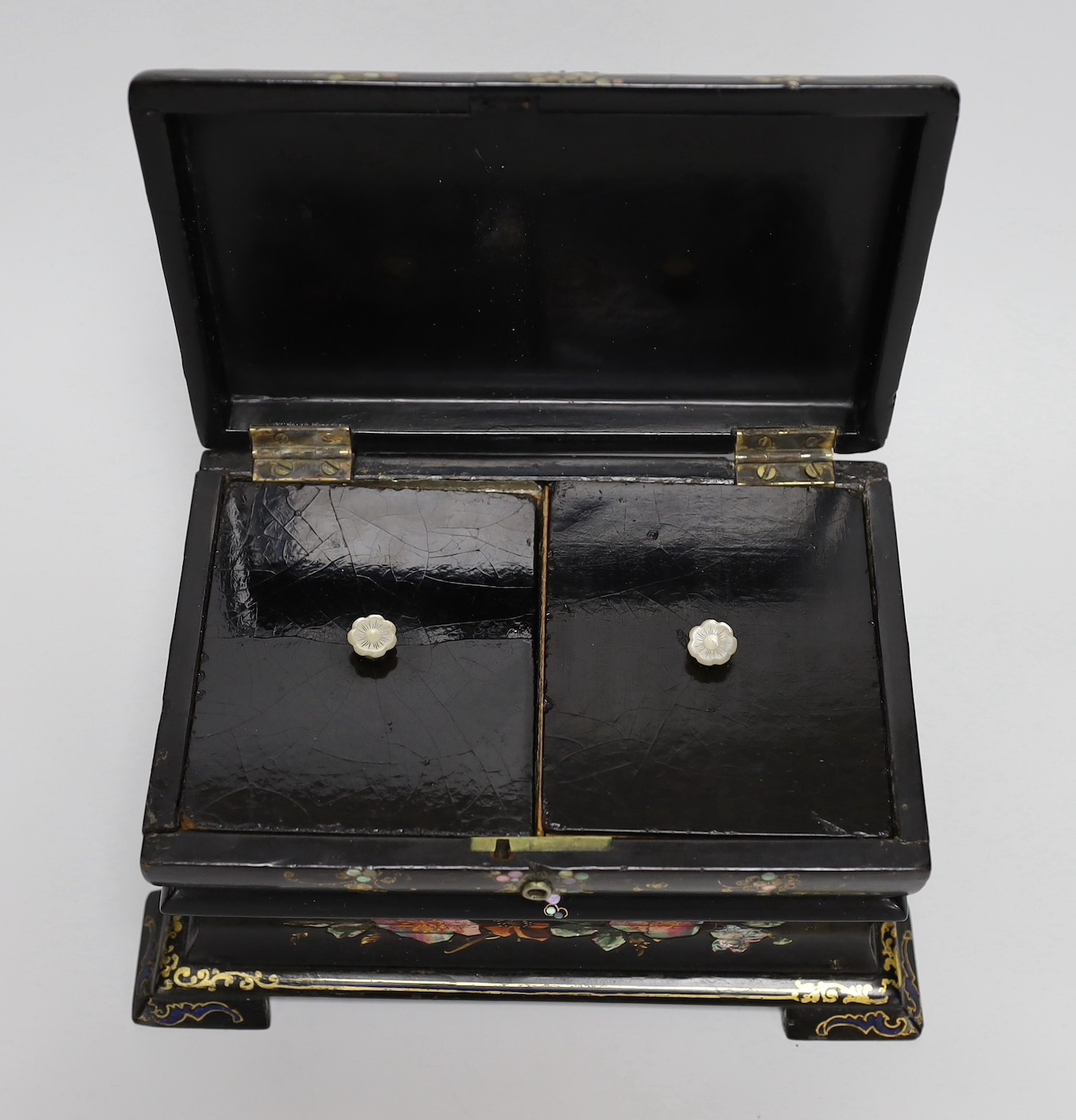 A Victorian painted and mother of pearl inlaid papier mache tea caddy. 23cm wide